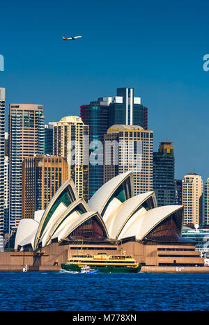 Un avion survole la ville de Sydney et de l'opéra comme un ferry et de l'eau passer par taxi, Sydney, Nouvelle-Galles du Sud, Australie, Pacifique Banque D'Images