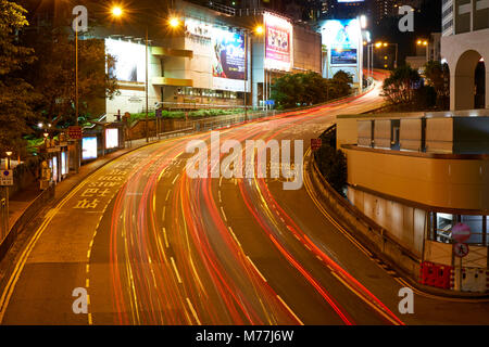Des sentiers de lumière de voiture sur une route très fréquentée à Central, Hong Kong Island de nuit, Hong Kong, Chine, Asie Banque D'Images