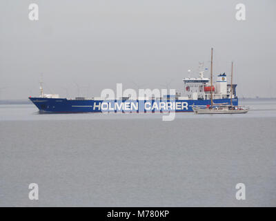 Sheerness, Kent, UK. 9 mars, 2018. Météo France : un ciel couvert et calme matin dans Sheerness. La Belgique lits 1 mâts 'yacht Zenobe gramme' (longueur : 29m) avec le transporteur de fret 'Shipper' dans l'arrière-plan. Credit : James Bell/Alamy Live News Banque D'Images