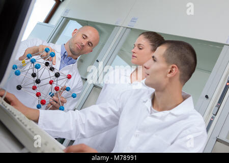 Les étudiants avec teacher holding molecular model Banque D'Images