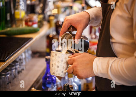 Mains Barista pouring cappuccino de lait est Banque D'Images
