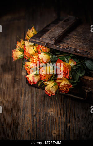 Bouquet de roses orange sur un fond de bois vintage Banque D'Images