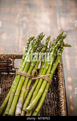 Close up de grappes de frais vert asperges dans panier en osier Banque D'Images