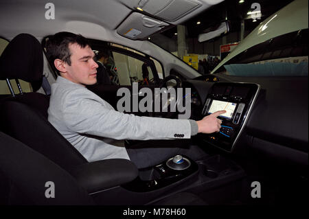 La manipulation du pilote un écran tactile dans la cabine d'une nouvelle voiture électrique. PLUG-exposition en Ukraine en 2018. Le 2 mars 2018. Kiev Ukraine Banque D'Images