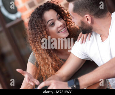 Couple heureux en utilisant un smartphone assis en terrasse Banque D'Images