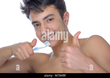 Cute adolescent avec fond blanc, portant des bagues sur les dents. Utilisez une brosse à dents et une brosse à dents pour le nettoyage. Banque D'Images