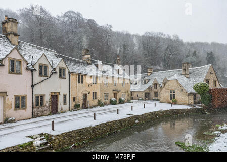 Les maisons couvertes de neige par par Brook à Castle Combe, Wiltshire, Angleterre, Royaume-Uni, Europe Banque D'Images