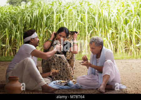 Famille d'agriculteurs indiens en train de déjeuner dans la zone Banque D'Images