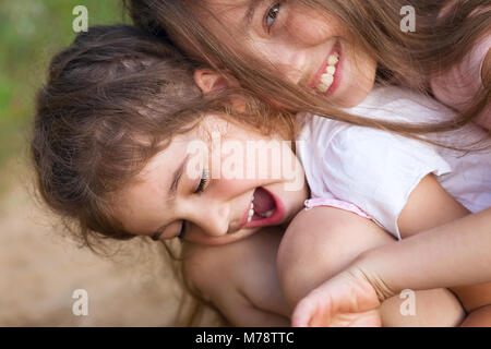 Deux petites filles rire heureux et s'étreindre au parc d'été Banque D'Images