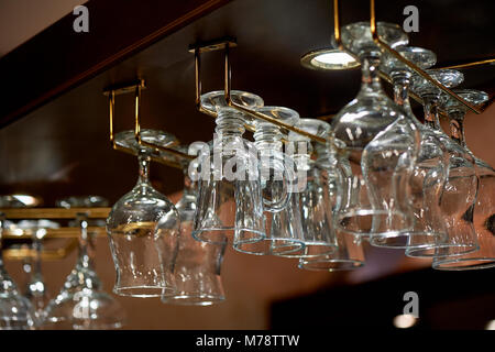 Verre à vin verres accrocher sur les porteurs au-dessus du bar.L'atmosphère de la soirée pub, restaurant, café Banque D'Images