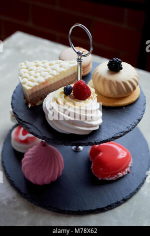 Des gâteaux sur une ardoise foncé stand superposés.Desserts. Table doux Banque D'Images