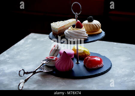 Des gâteaux sur une ardoise foncé stand superposés.Desserts. Table doux Banque D'Images