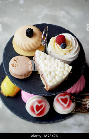 Des gâteaux sur une ardoise foncé stand superposés.Desserts. Table doux Banque D'Images