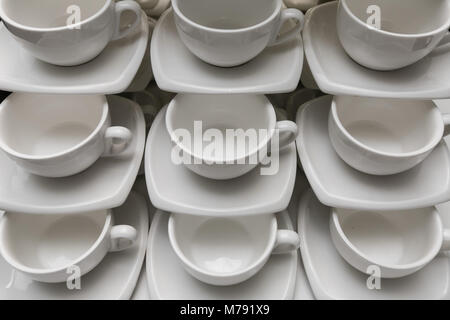 Nombre de lignes blanc propre tasse à café, cuillère à café et soucoupe sur la table. Mug vide mis en ligne préparer pour pause café Banque D'Images