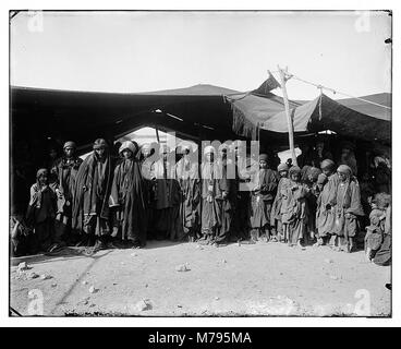 Des bédouines de la tribu Moab-Adwan sont représentées sur cette photographie, debout devant leur tente. L'image offre un aperçu des pratiques culturelles et des modes de vie des tribus bédouines au moyen-Orient. Banque D'Images