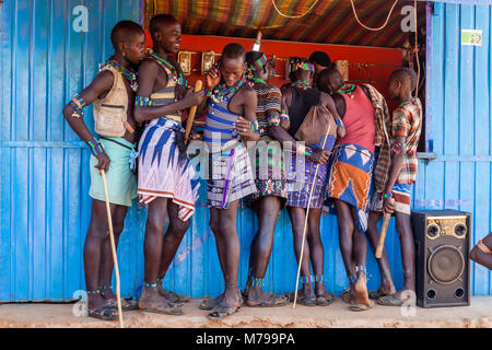Les jeunes hommes à l'extérieur un Hamar téléphone mobile (téléphone cellulaire) Shop pendant leur visite hebdomadaire au marché de Dimeka Tribal, vallée de l'Omo, Ethiopie Banque D'Images