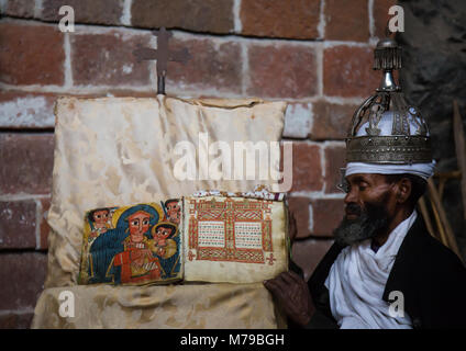 Portrait d'un prêtre orthodoxe éthiopienne tenant une bible dans l'église nakuto lab cave, région d'Amhara, Lalibela, Éthiopie Banque D'Images