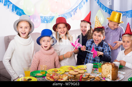 Garçons et filles émotionnel heureux de fêter l'anniversaire d'un ami pendant le dîner Banque D'Images