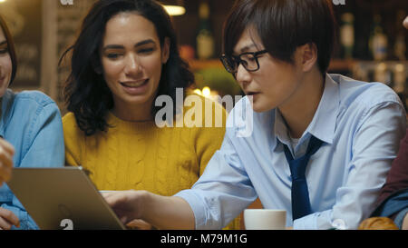 Groupe diversifié de collègues a Business Lunch au Café/Restaurant, qu'ils pensent de la résolution de problèmes et d'utiliser un ordinateur portable. De belles personnes Banque D'Images