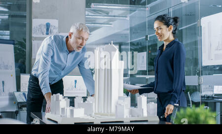 Dans le bureau d'architecture Ingénieur femelle apporte les bleus et leur montre d'architecte senior, ils discutent du projet. Ils travaillent comme des planificateurs urbains Banque D'Images