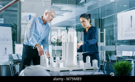 Dans le bureau d'architecture Ingénieur femelle apporte les bleus et leur montre d'architecte senior, ils discutent du projet. Ils travaillent comme des planificateurs urbains Banque D'Images