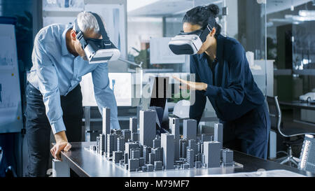 Architectes, hommes et femmes portant des casques de réalité augmentée en 3D travail ville modèle. Office Professionnel de haute technologie les gens utilisent le modèle de réalité virtuelle Banque D'Images