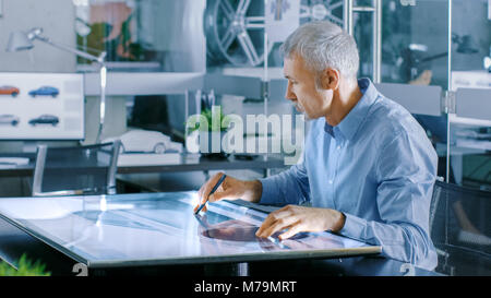 Designer automobile expérimenté travaille avec afficheur numérique tablette graphique Table Touschreen, dessin Croquis d'un nouveau prototype de voiture. Banque D'Images