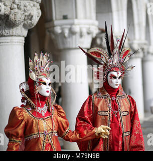 Venise, Italie - 5 Février, 2018 : la femme et l'homme avec une superbe robe rouge et or près de Palais Ducal Banque D'Images