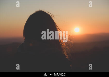 Une jeune femme regarde au-dessus de Dartmoor, le Royaume-Uni dans le soleil couchant. Banque D'Images