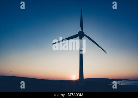 Une éolienne permet de produire de l'électricité se profile par le coucher du soleil à Saltash, Cornwall Banque D'Images