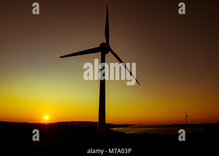 Une éolienne permet de produire de l'électricité se profile par le coucher du soleil à Saltash, Cornwall Banque D'Images