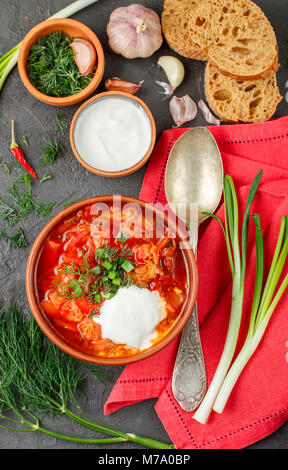 L'ukrainien et russe rouge végétales traditionnelles - soupe borsch dans une plaque d'argile sur черной arrière-plan. Selective focus Banque D'Images