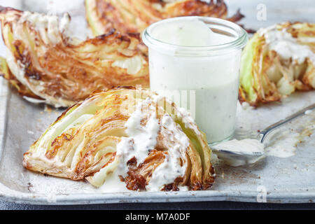 Morceaux de chou cuit avec des épices et sauce yogourt, moutarde et herbes. Selective focus Banque D'Images