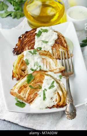 Morceaux de chou cuit avec des épices et sauce yogourt, moutarde et herbes. Selective focus Banque D'Images