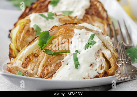 Morceaux de chou cuit avec des épices et sauce yogourt, moutarde et herbes. Selective focus Banque D'Images