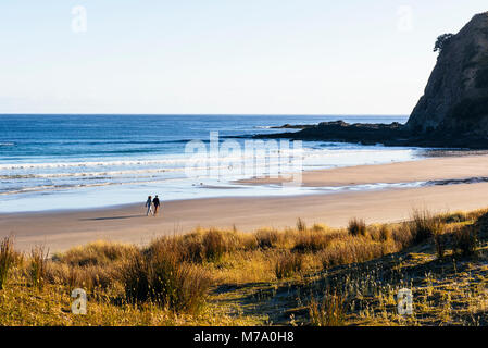 Couple walking on beach at Tapotupotu Bay, près du cap Reinga, île du Nord, Nouvelle-Zélande Banque D'Images