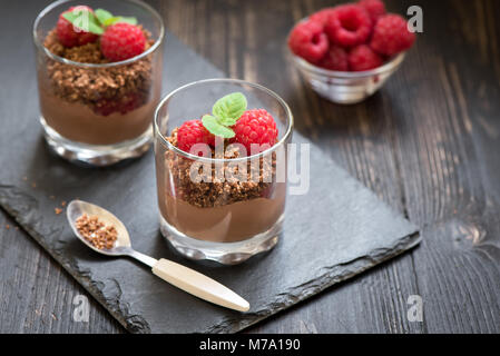 Dessert au chocolat dans les verres avec les framboises. Mousse au chocolat ou au lait en partie lunettes avec les baies fraîches, copiez l'espace. Banque D'Images