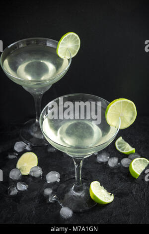 Marguerite Сocktail avec de la chaux et de la glace sur la table en pierre noire, copiez l'espace. Cocktail Margarita classique. Banque D'Images
