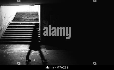Femme marche dans un passage souterrain. Banque D'Images