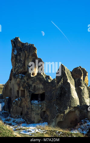 Lune et sentier d'avion dans le ciel surplombant le paysage lunaire de la Cappadoce, Turquie Banque D'Images