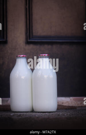 Des bouteilles de lait sur une porte avant l'étape d'une maison à Glasgow, Ecosse Banque D'Images