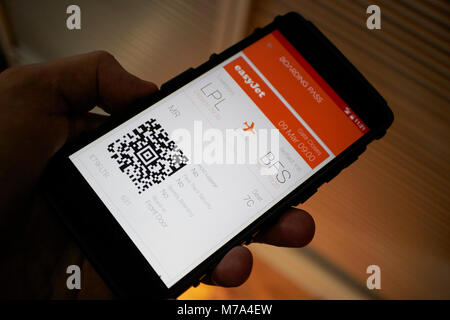 Man holding d'embarquement électronique en utilisant l'application easyjet sur un smartphone Banque D'Images