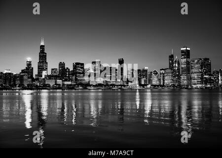 Chicago, Illinois, USA Skyline nuit sur le lac Michigan au crépuscule avec les villes Lumières se reflétant dans l'eau. Banque D'Images