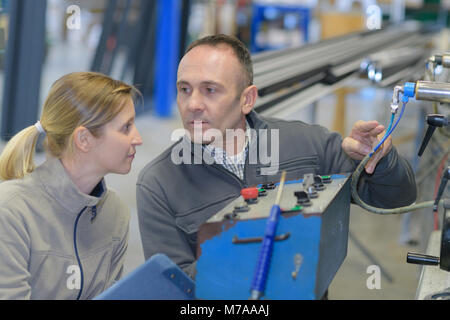 L'homme et la femme à la machine cnc Banque D'Images