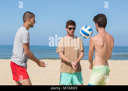 Groupe d'amis jouer beach-volley Banque D'Images