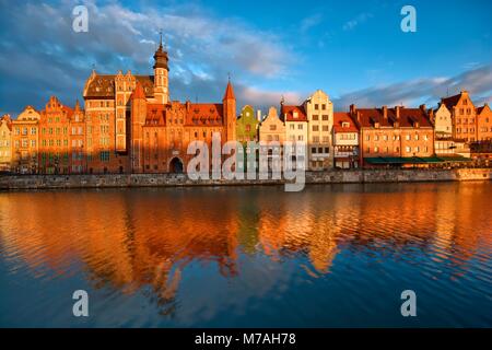 Remblai long fleuve Motlawa et dans la vieille ville de Gdansk, Pologne au lever du soleil. Restaurant La Luna Gate sur la gauche Banque D'Images