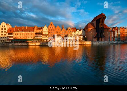 Remblai long fleuve Motlawa et dans la vieille ville de Gdansk, Pologne au lever du soleil. La grue du port médiéval - symbole le plus caractéristique de Gdansk sur la Banque D'Images