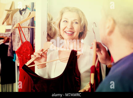Portrait of smiling mature couple essayant sur nouvelle robe en salon d'essayage à la boutique Banque D'Images