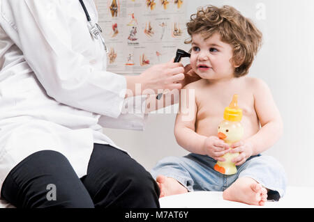 Femme Médecin examinant un baby boy's ear avec un otoscope Banque D'Images