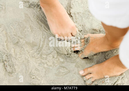 Up d'un homme et d'une femme debout sur la plage Banque D'Images